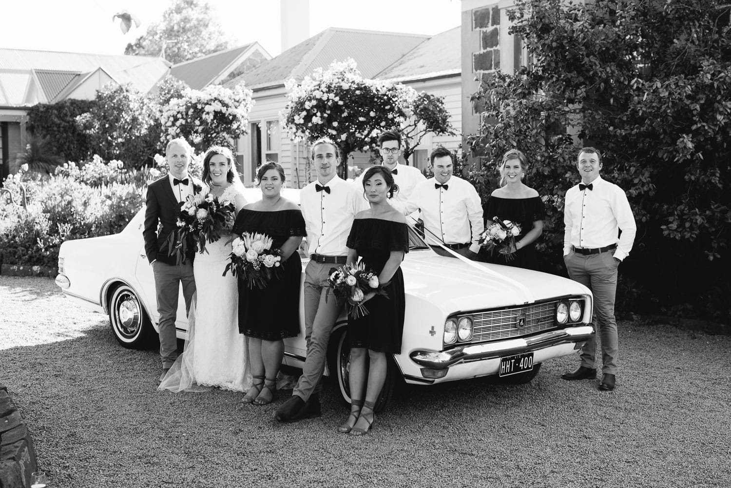 Wedding party leaning on car at Narmbool Sovereign Hill