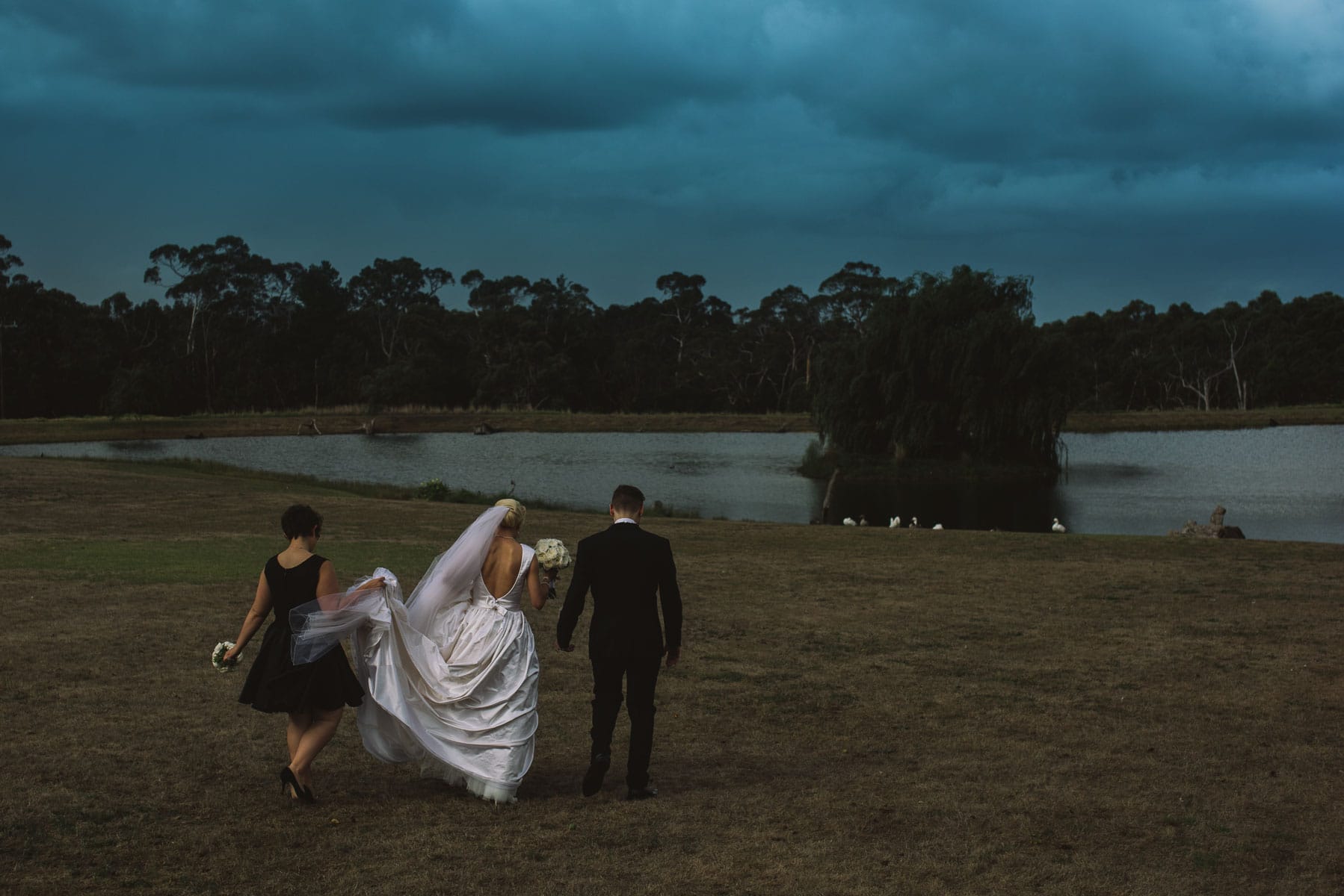 Moody portrait of wedding couple with stormy sky