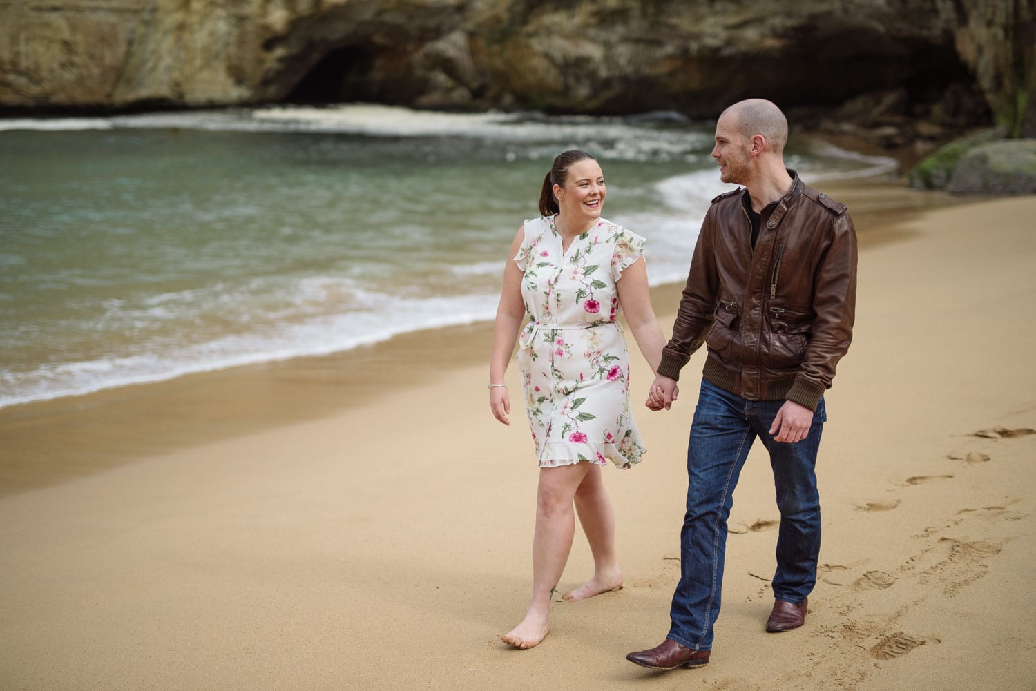 Couple walk on the beach holding hands