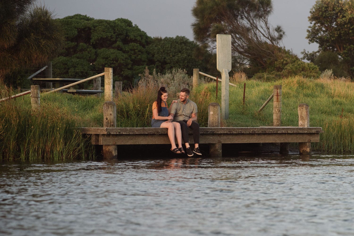 Couple sitting by the water at Apollo bay during their engagement session