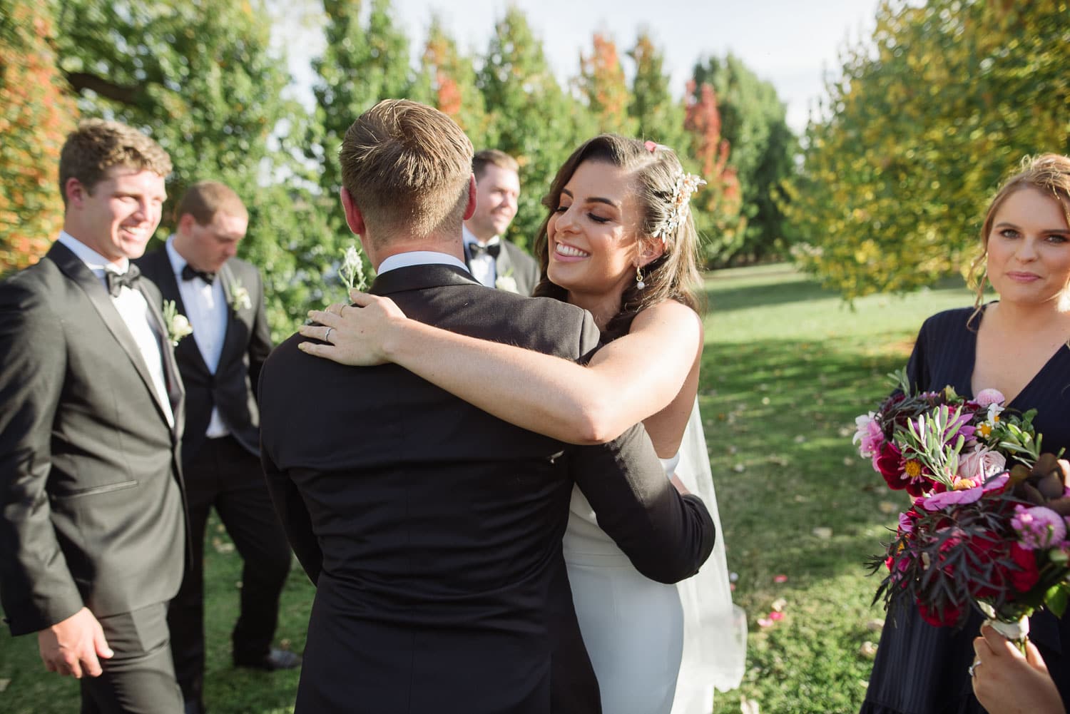 Bride and groom hugging at a backyard wedding