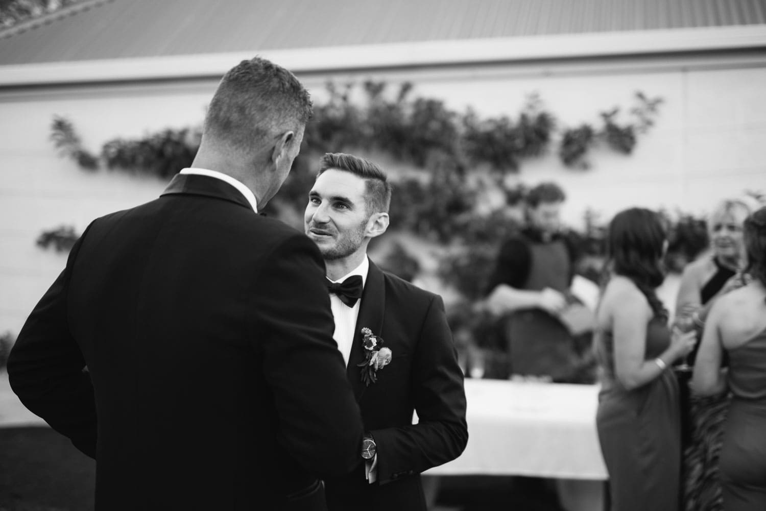 Groom and guests enjoy drinks in their garden