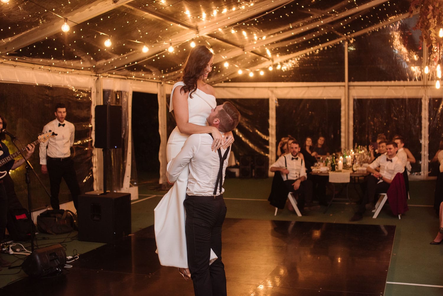 Groom lifts bride during their first dance