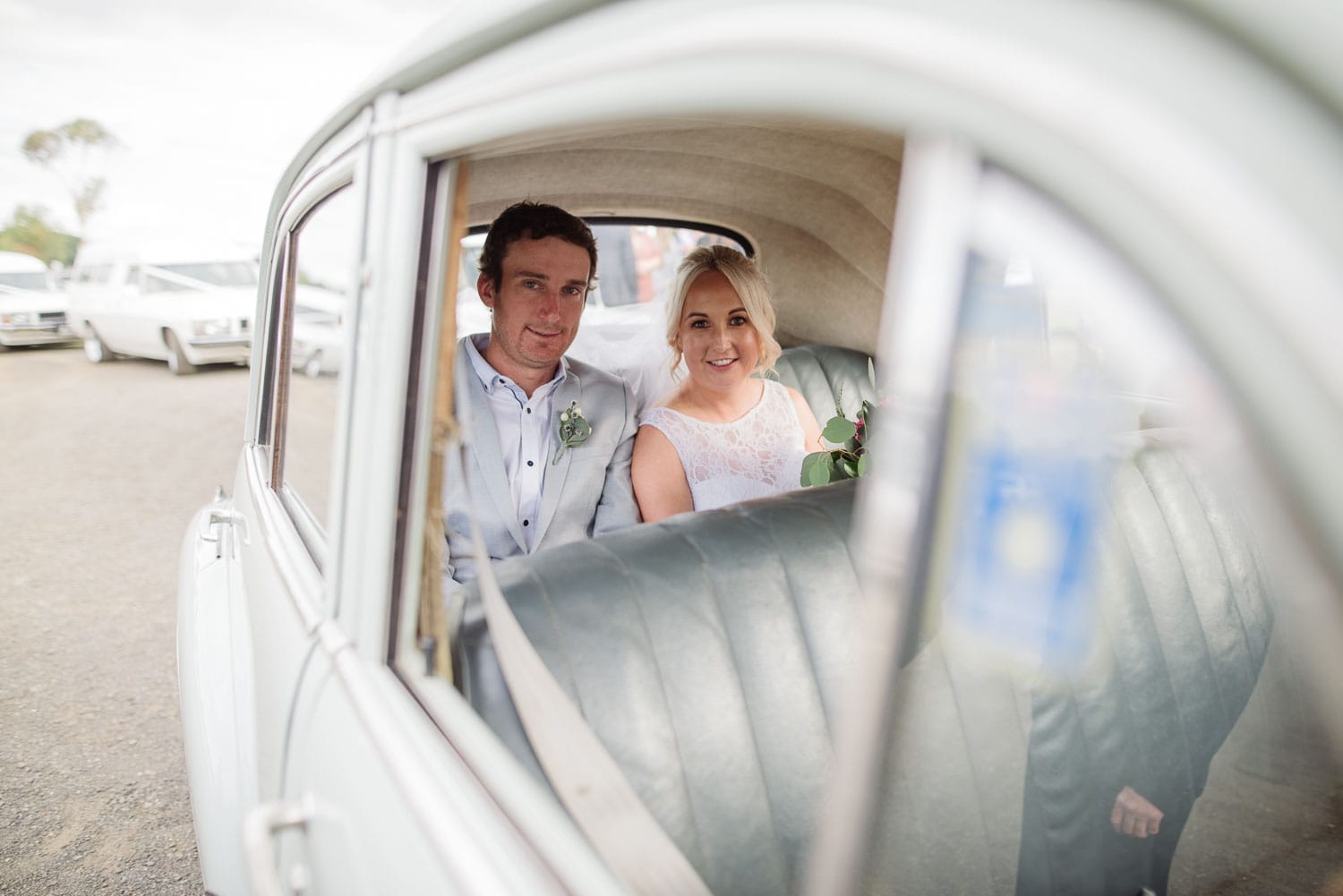 Bride and Groom sitting in their wedding car