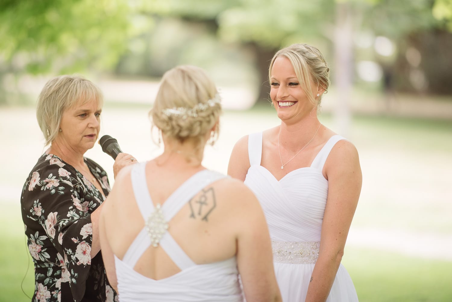 Brides laughing during their wedding ceremony at colac botanic gardens