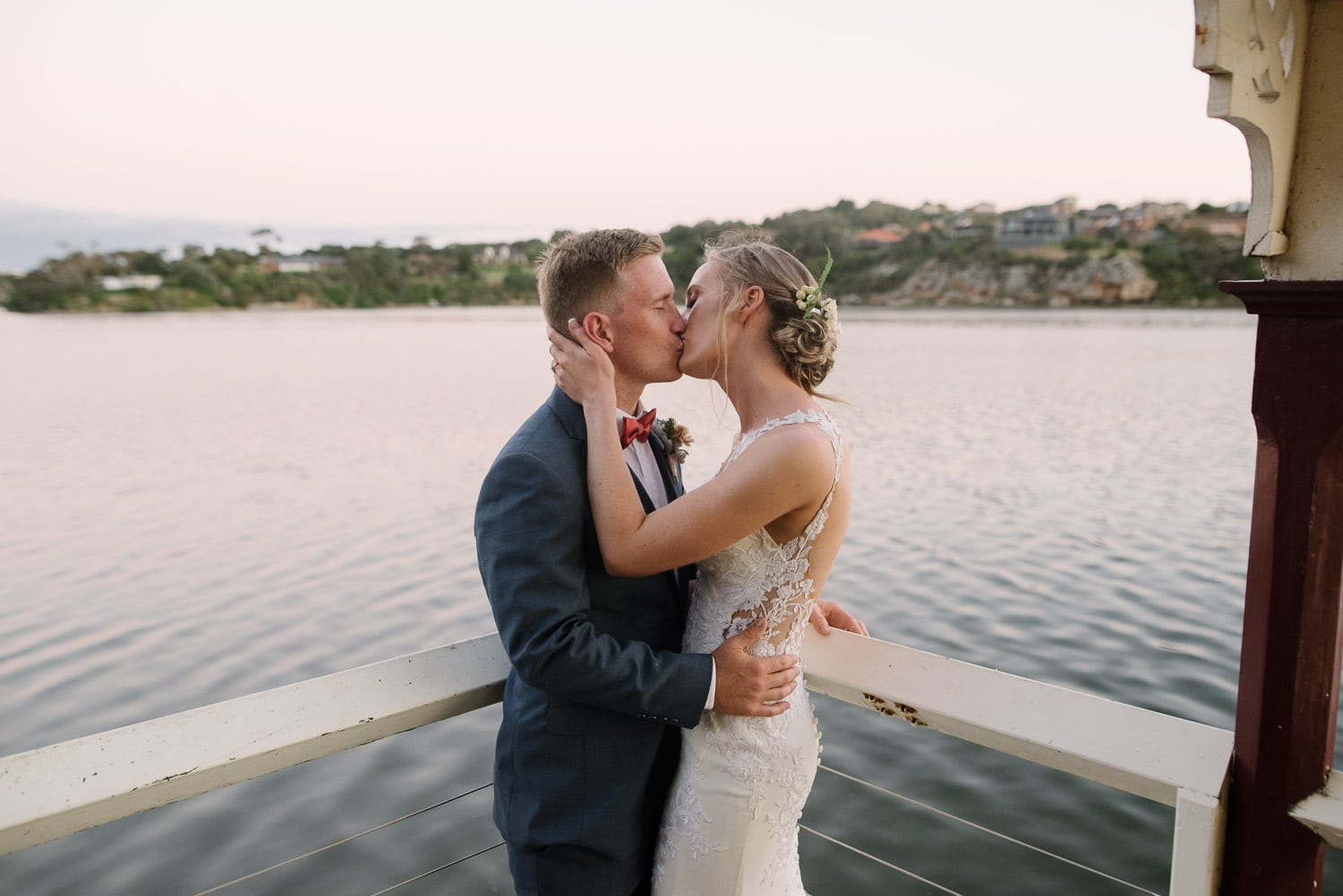 Couple kiss during their wedding reception at Proudfoots on the River