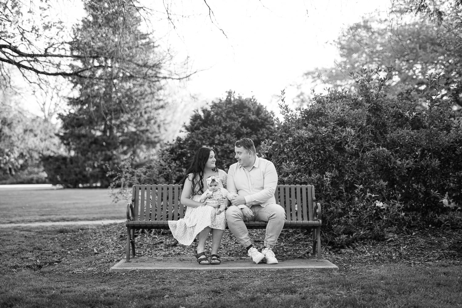 parents and child sitting on a bench